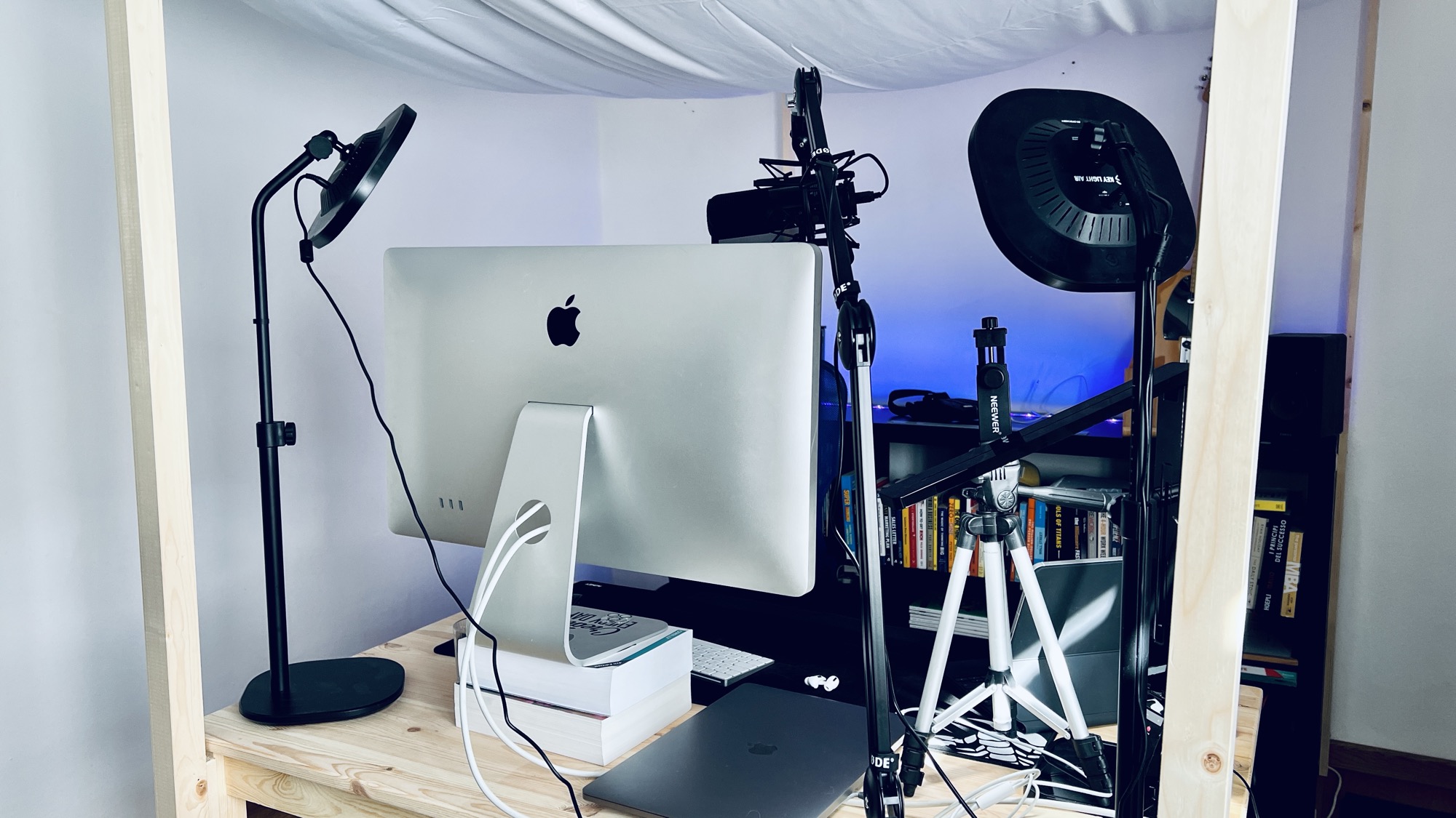 Complete video recording desk setup with iMac, wooden acoustic frame structure, blankets, and equipment
